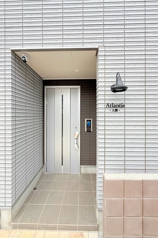 天井に防犯カメラ、壁にライトのある玄関(アトランティス入間)